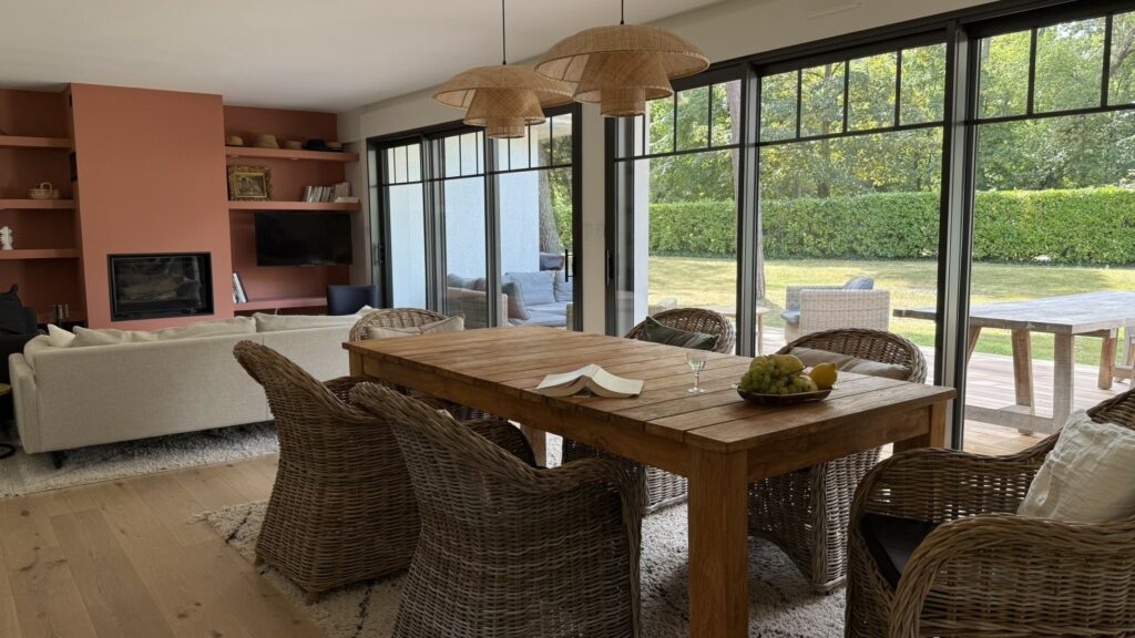 Pièce de vie lumineuse avec grandes baies vitrées, mobilier aux matières naturelles et insert contemporain - projet de rénovation à Le Touquet Paris Plage par La Didascalie, agence à Mouvaux.